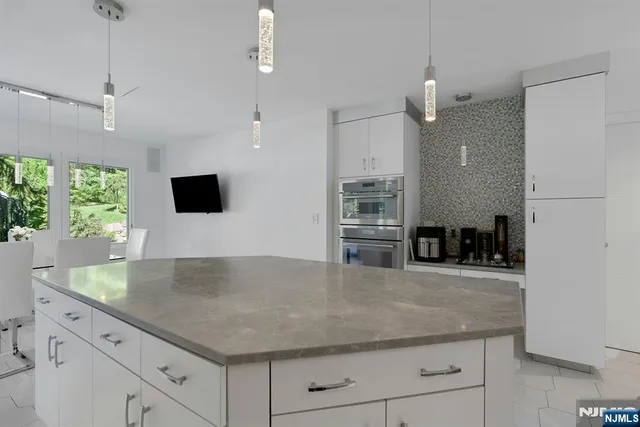 a kitchen with granite countertop a counter space and stainless steel appliances