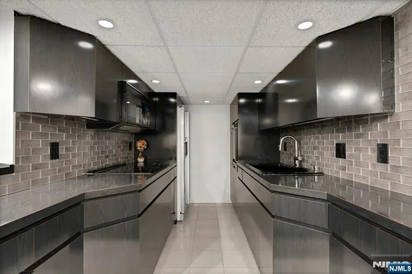 a kitchen with stainless steel appliances a sink a stove and cabinets