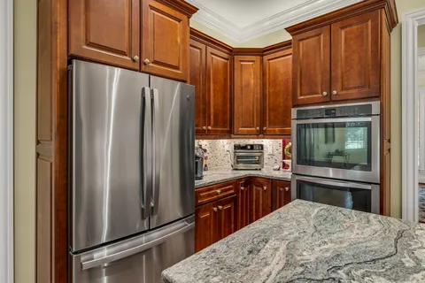 a kitchen with kitchen island granite countertop a sink stove and refrigerator