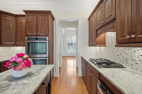 a dining room with wooden floor a glass table and chairs