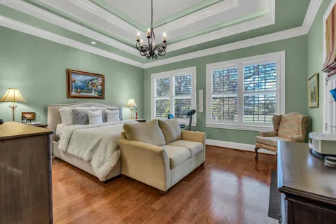 a bedroom with a large bed and a chandelier