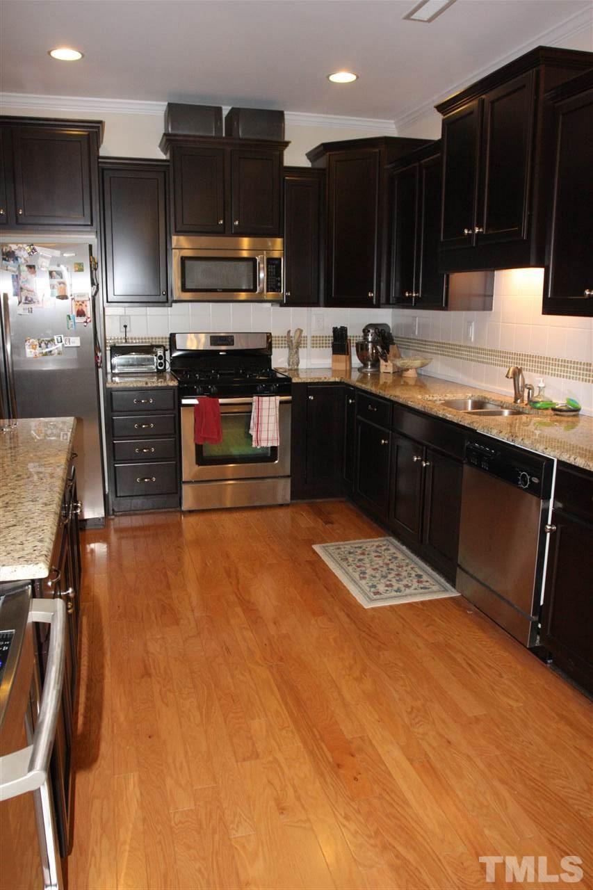 2402 Swans Rest Way Raleigh, NC 27606 - Photo 7 of 19 a kitchen with stainless steel appliances granite countertop a stove top oven a sink and dishwasher