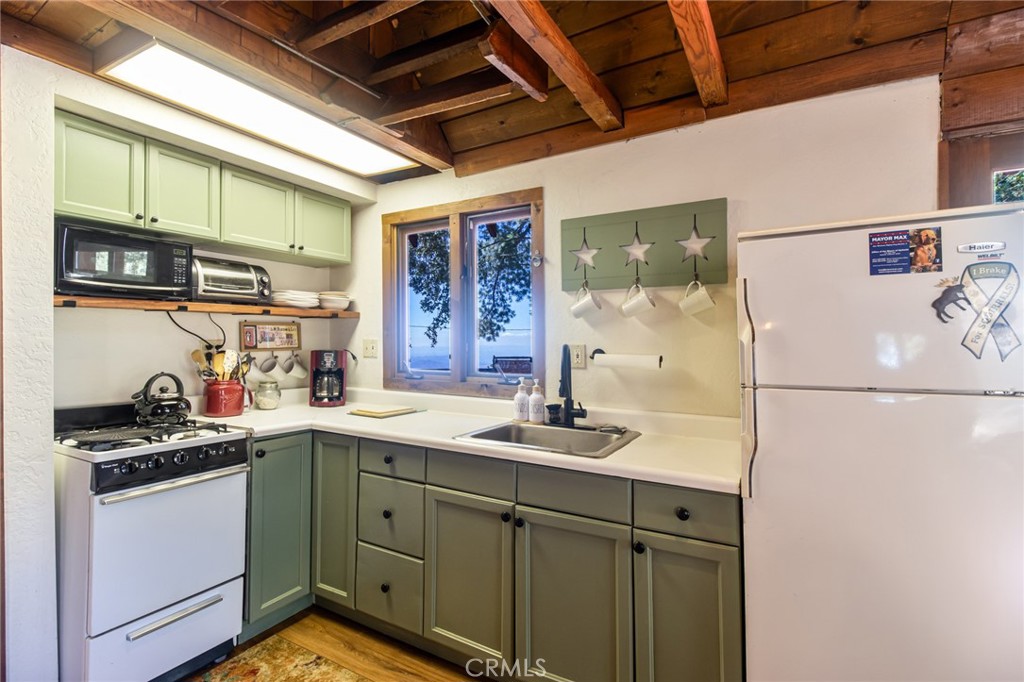 24387 Rocky Point Road Idyllwild, CA 92549 - Photo 25 of 29 a kitchen with stainless steel appliances granite countertop a sink stove and refrigerator