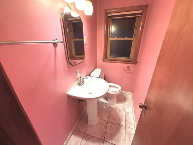 a bathroom with a toilet and a mirror