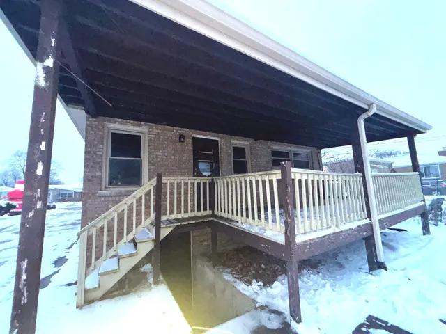 a backyard of a house with wooden fence and large trees