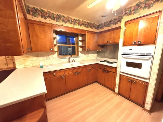 a view of a kitchen with wooden floor and iron stairs