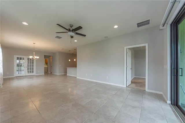 a view of a livingroom with a chandelier fan and windows