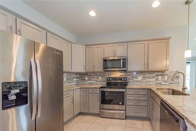 a kitchen with stainless steel appliances granite countertop a refrigerator stove microwave and sink