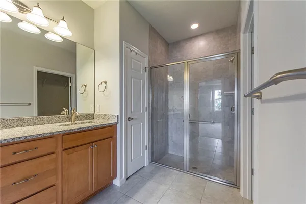 a bathroom with a granite countertop sink mirror and shower