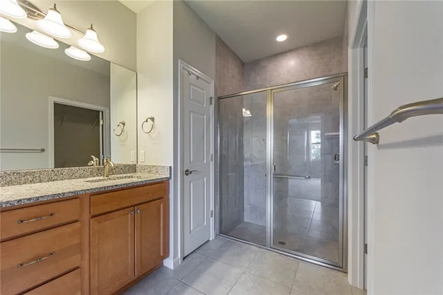 a bathroom with a granite countertop sink mirror and shower