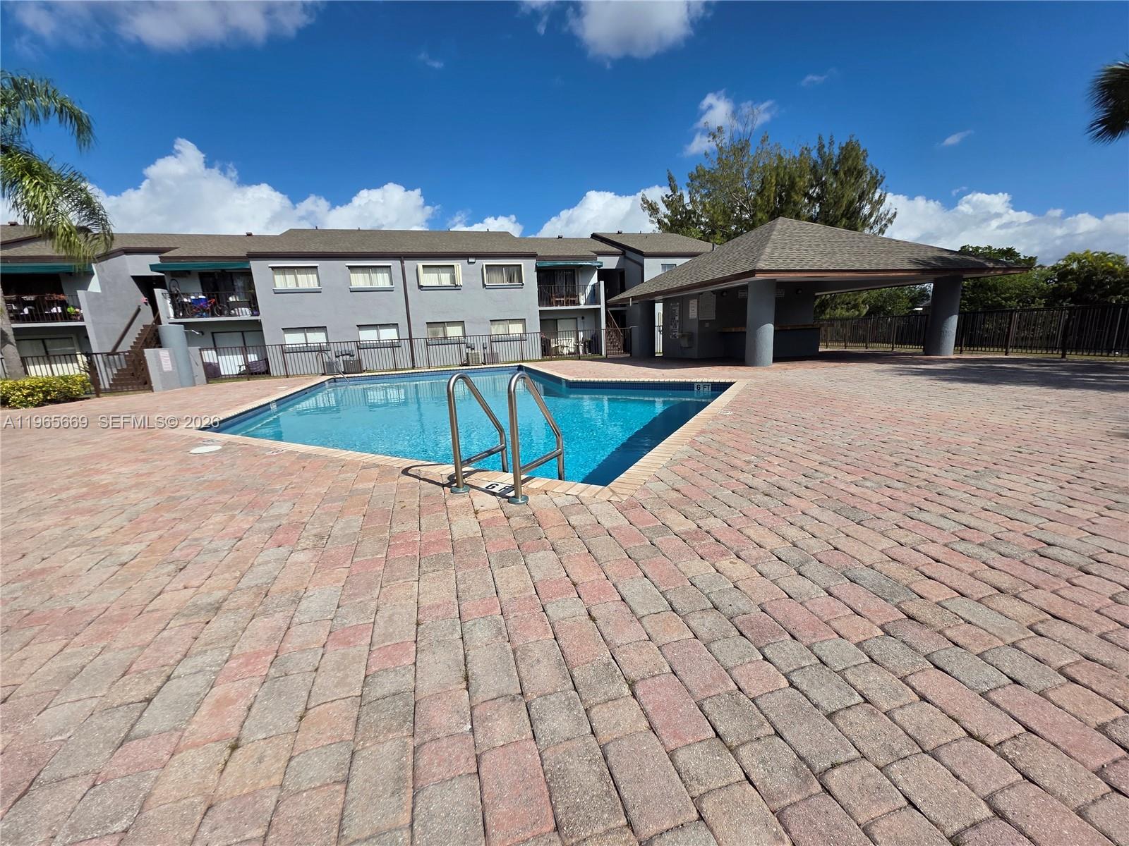 7421 Southwest 152nd Avenue, Unit 9101 Miami, FL 33193 - Photo 17 of 32 a view of a white house with a swimming pool and a yard