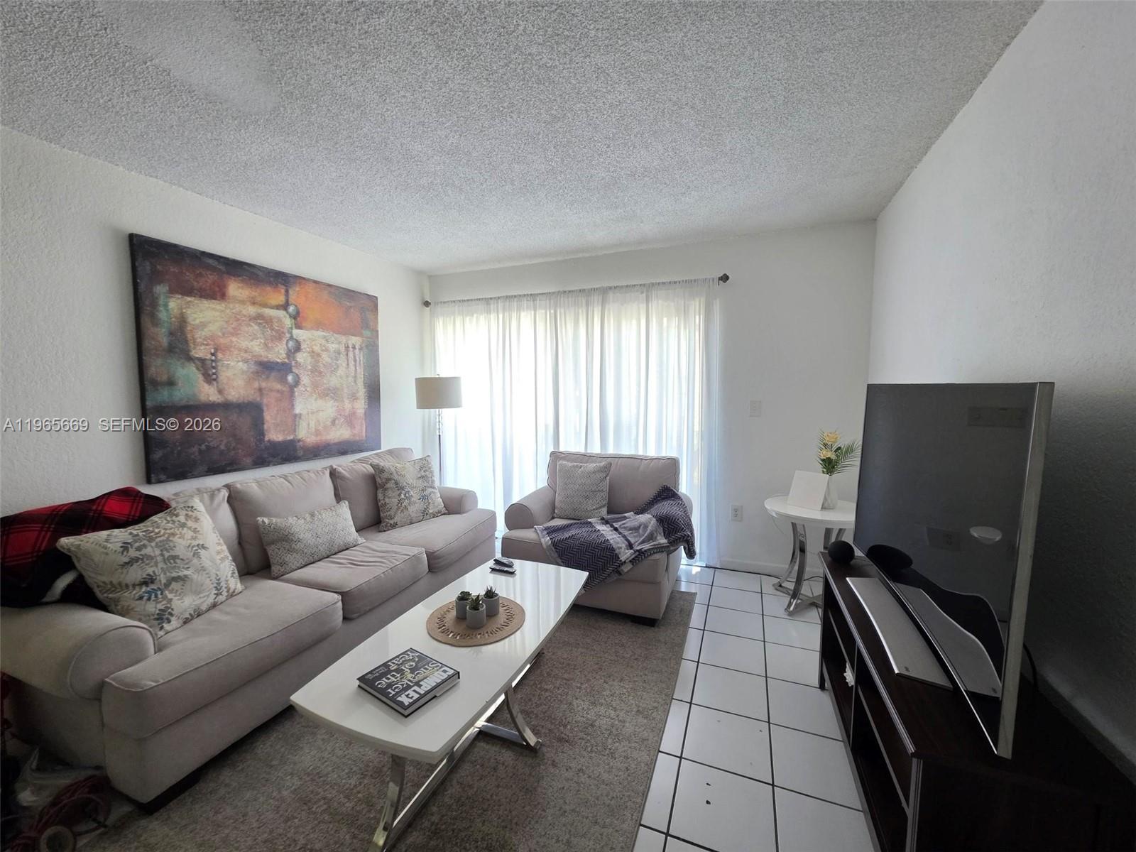 7421 Southwest 152nd Avenue, Unit 9101 Miami, FL 33193 - Photo 19 of 32 a living room with furniture and a flat screen tv