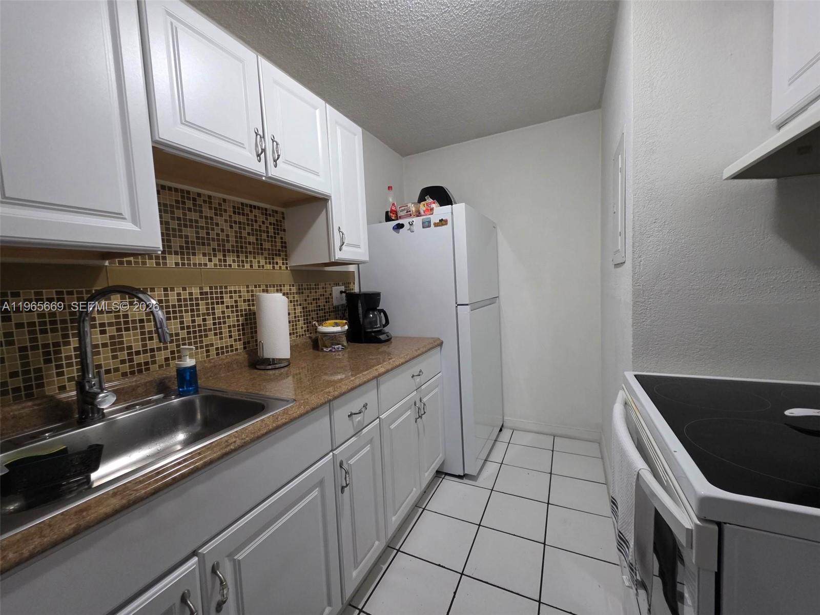 7421 Southwest 152nd Avenue, Unit 9101 Miami, FL 33193 - Photo 20 of 32 a kitchen with stainless steel appliances a sink and cabinets