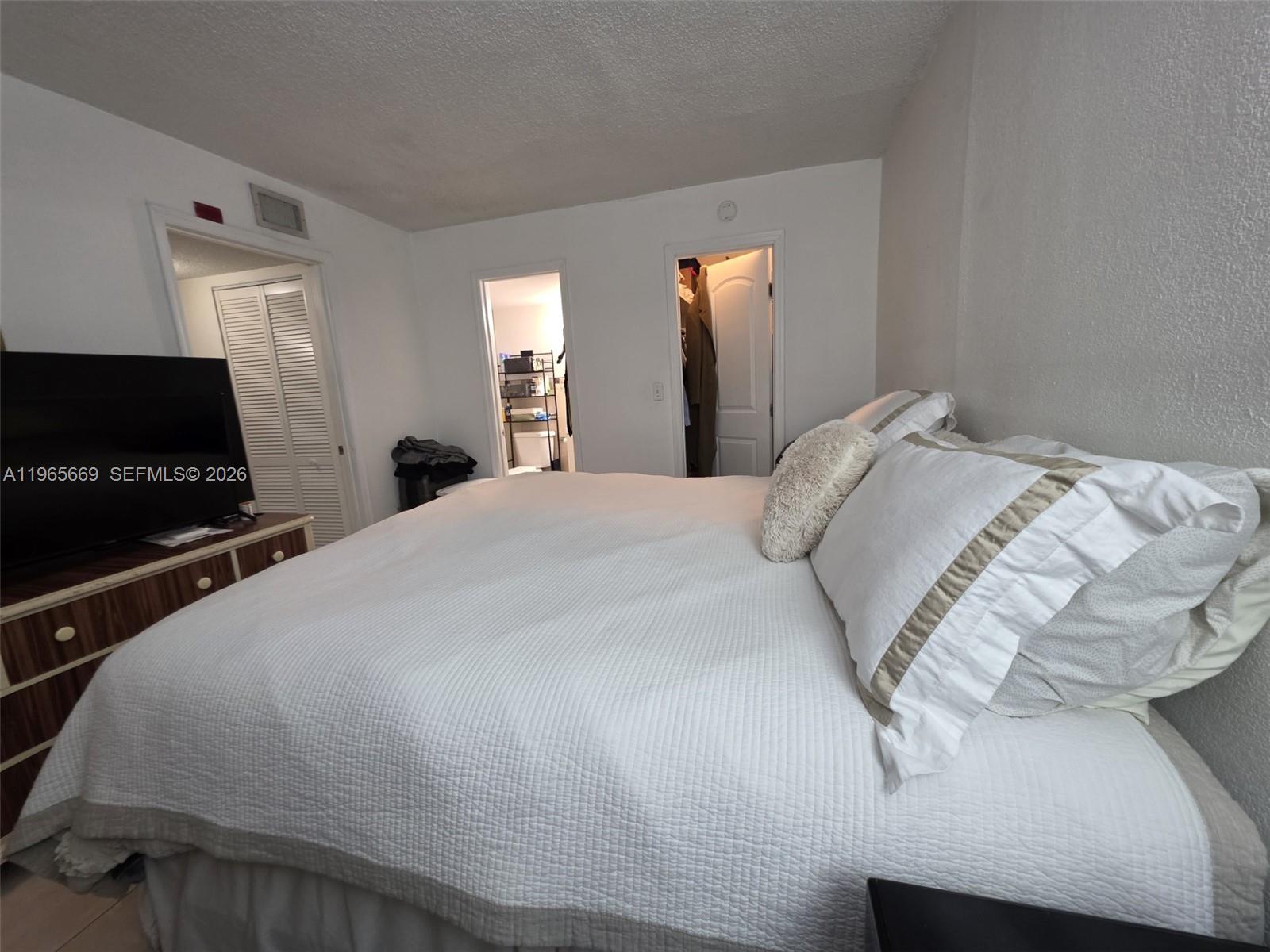7421 Southwest 152nd Avenue, Unit 9101 Miami, FL 33193 - Photo 22 of 32 a bedroom with a bed and a flat screen tv