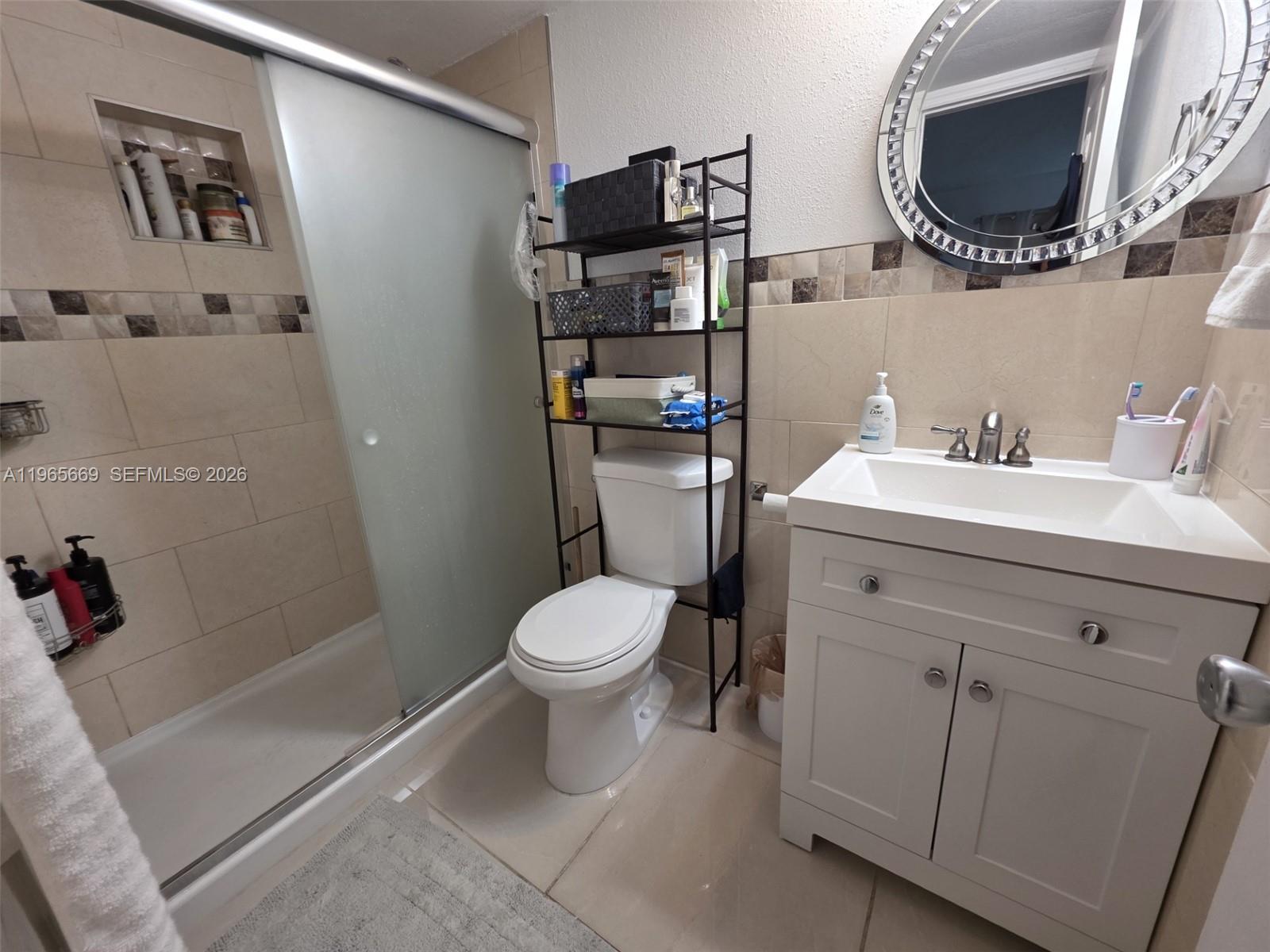 7421 Southwest 152nd Avenue, Unit 9101 Miami, FL 33193 - Photo 23 of 32 a bathroom with a sink a toilet and a mirror