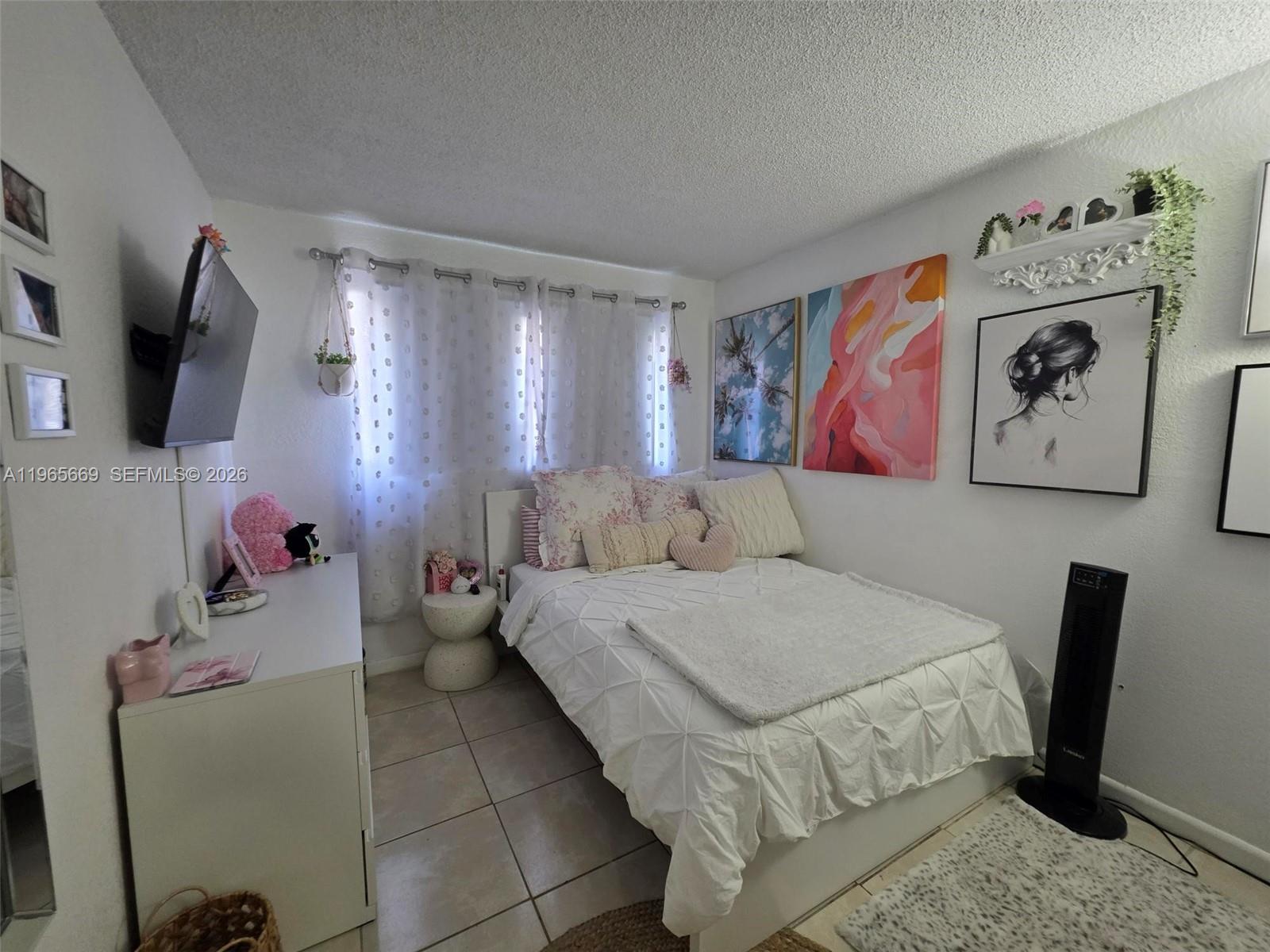 7421 Southwest 152nd Avenue, Unit 9101 Miami, FL 33193 - Photo 24 of 32 a bedroom with a bed and a flat screen tv