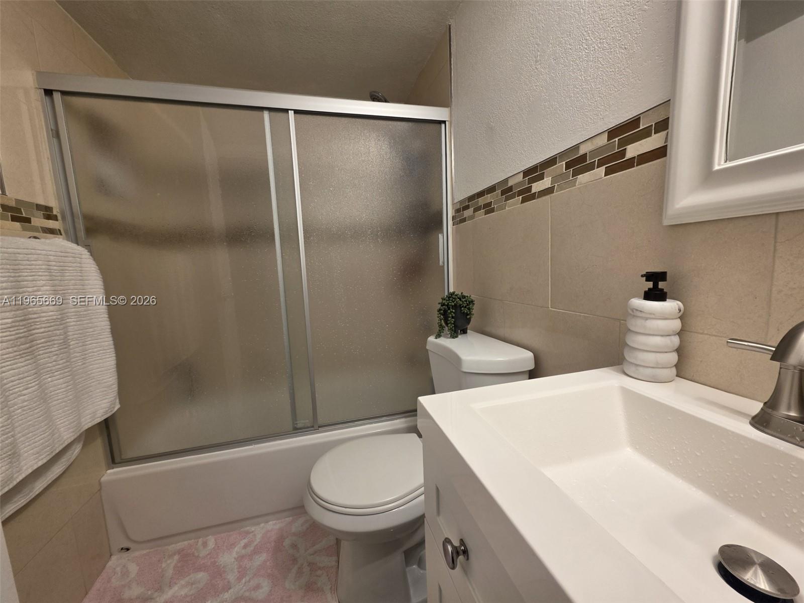 7421 Southwest 152nd Avenue, Unit 9101 Miami, FL 33193 - Photo 26 of 32 a bathroom with a sink a toilet and shower