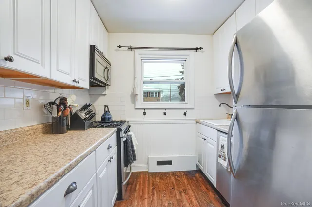 a kitchen with a sink a refrigerator and cabinets