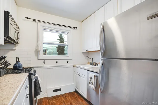 a kitchen with a sink a refrigerator and a stove top oven