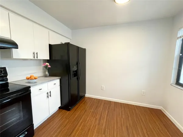 a kitchen with a refrigerator and a stove top oven