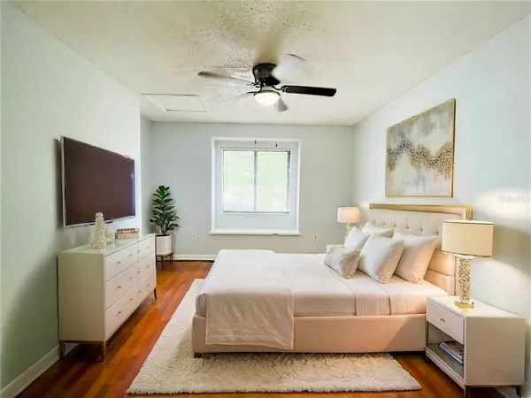 a bedroom with a large bed and a flat screen tv