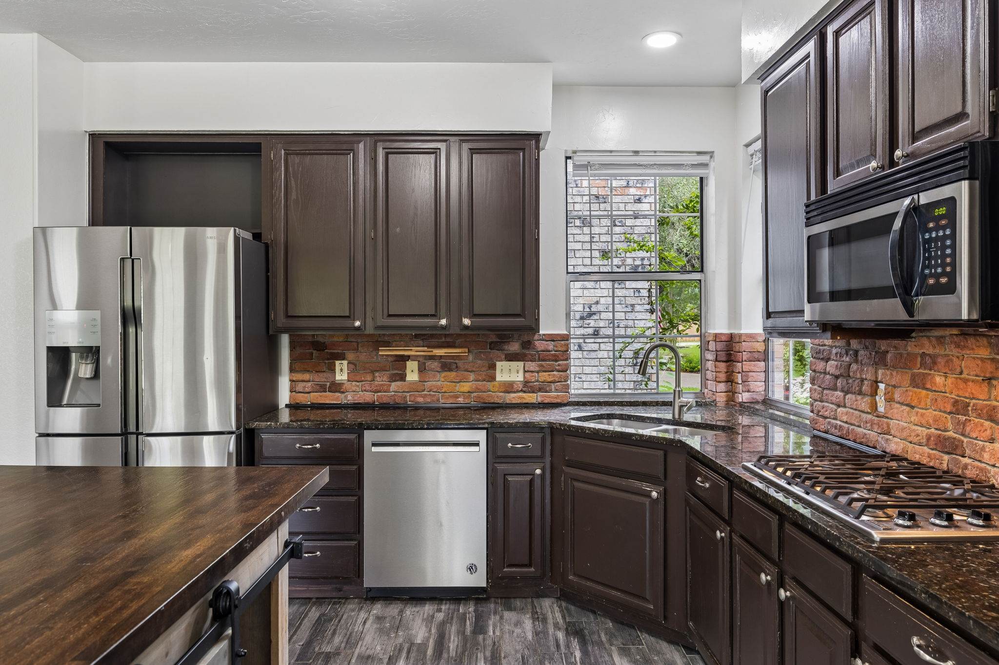 10400 O'Rourk Lane Austin, TX 78739 - Photo 27 of 33 a kitchen with granite countertop stainless steel appliances and wooden cabinets