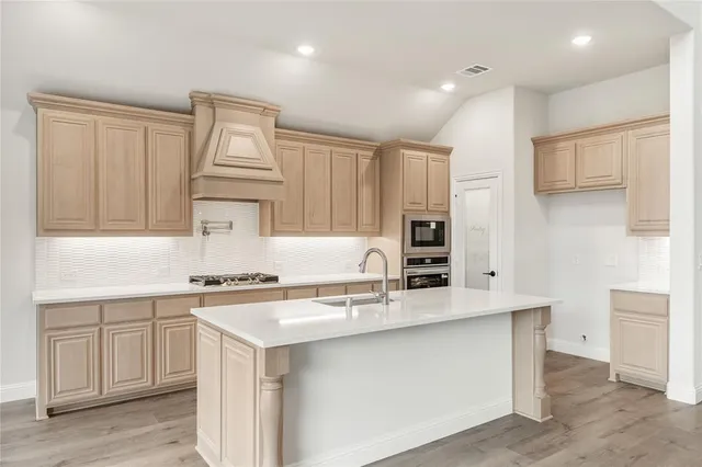 a kitchen with stainless steel appliances a sink stove and refrigerator