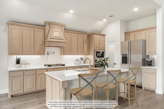 a kitchen with kitchen island a sink appliances and cabinets