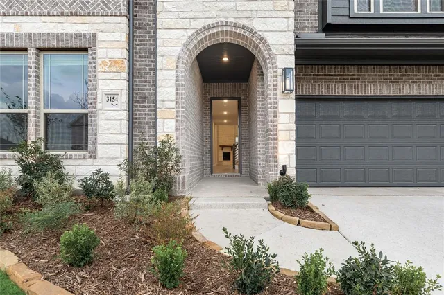 an entryway in a hall with wooden floor and a cabinet
