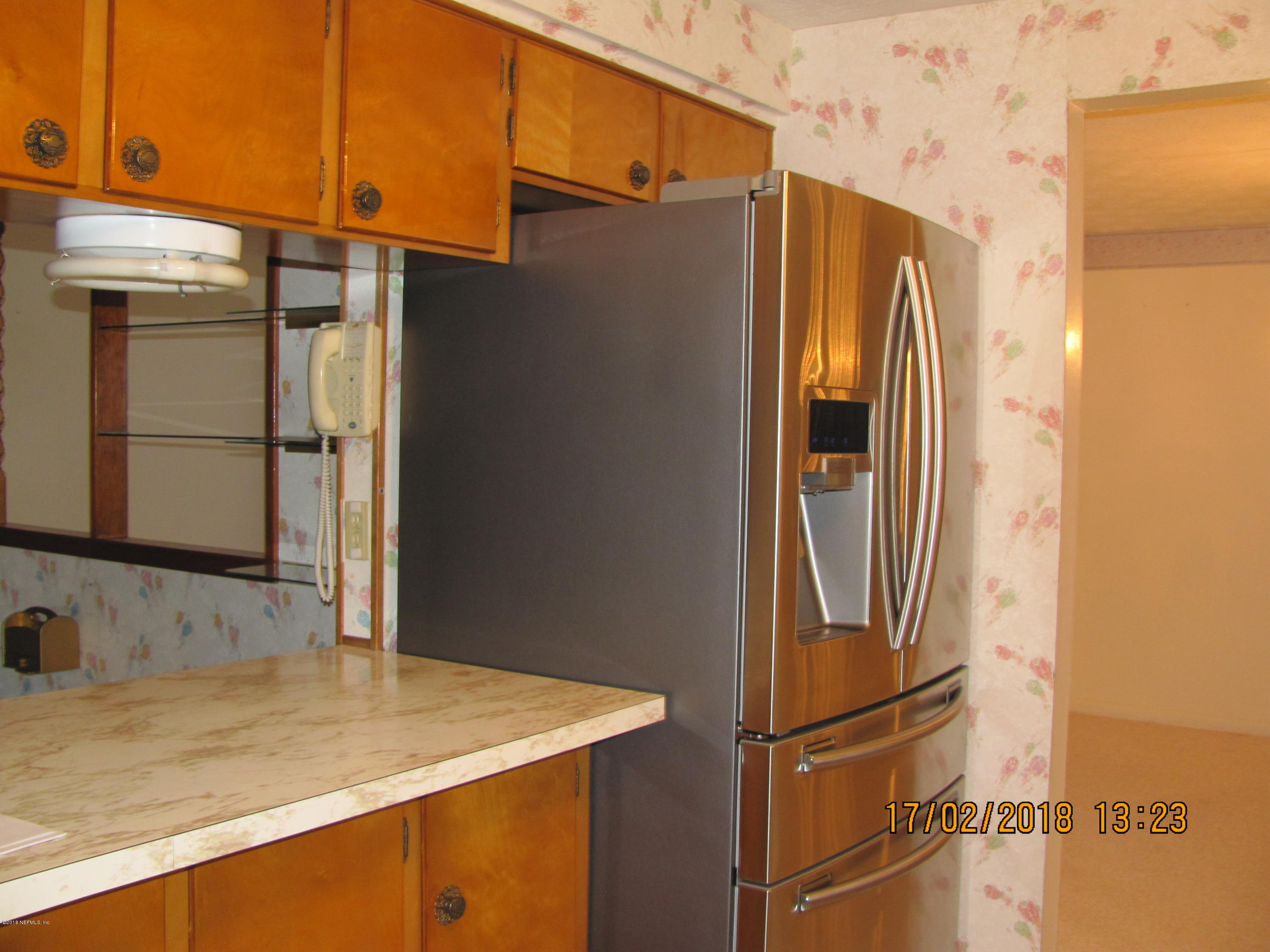 417 Sigsbee Road Orange Park, FL 32073 - Photo 20 of 21 a bathroom with a granite countertop sink and a refrigerator