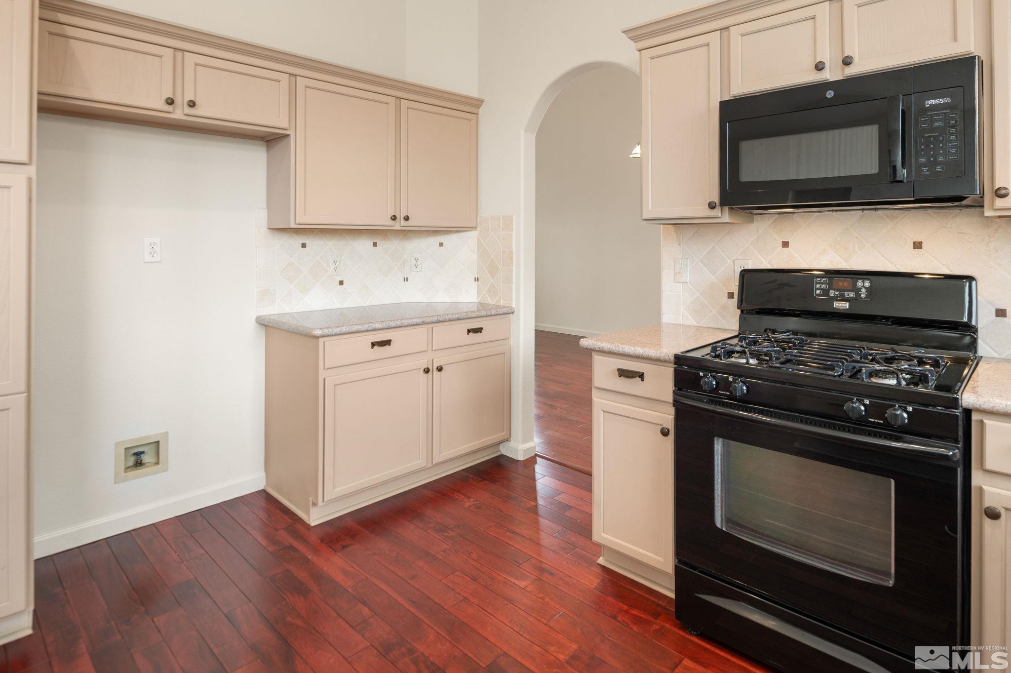 9635 Oakley Lane Reno, NV 89521 - Photo 11 of 40 a kitchen with stainless steel appliances a stove a microwave oven cabinets and a wooden floor