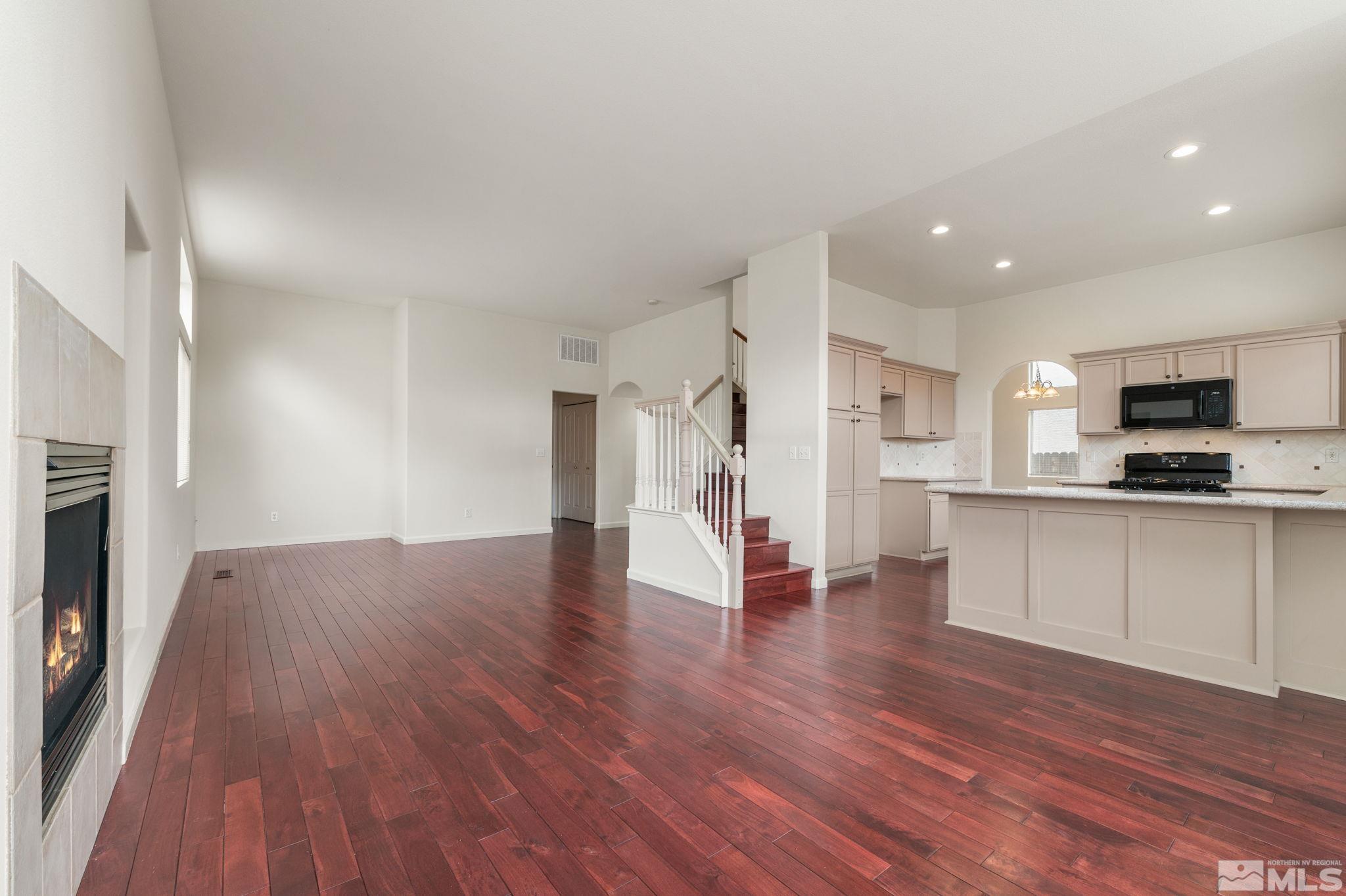 9635 Oakley Lane Reno, NV 89521 - Photo 16 of 40 a view of an empty room and kitchen with wooden floor
