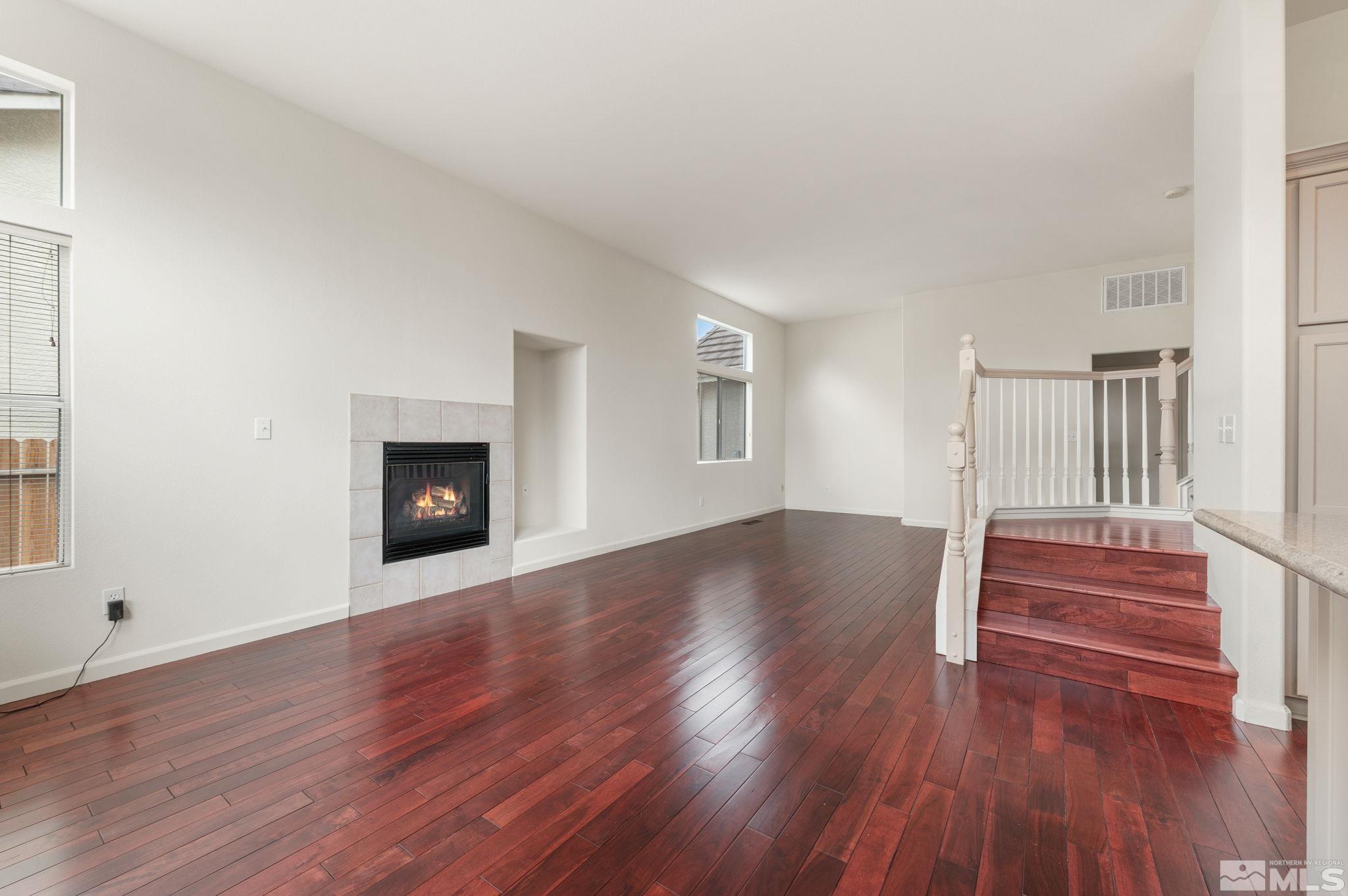 9635 Oakley Lane Reno, NV 89521 - Photo 18 of 40 a view of an empty room with wooden floor fireplace and a window