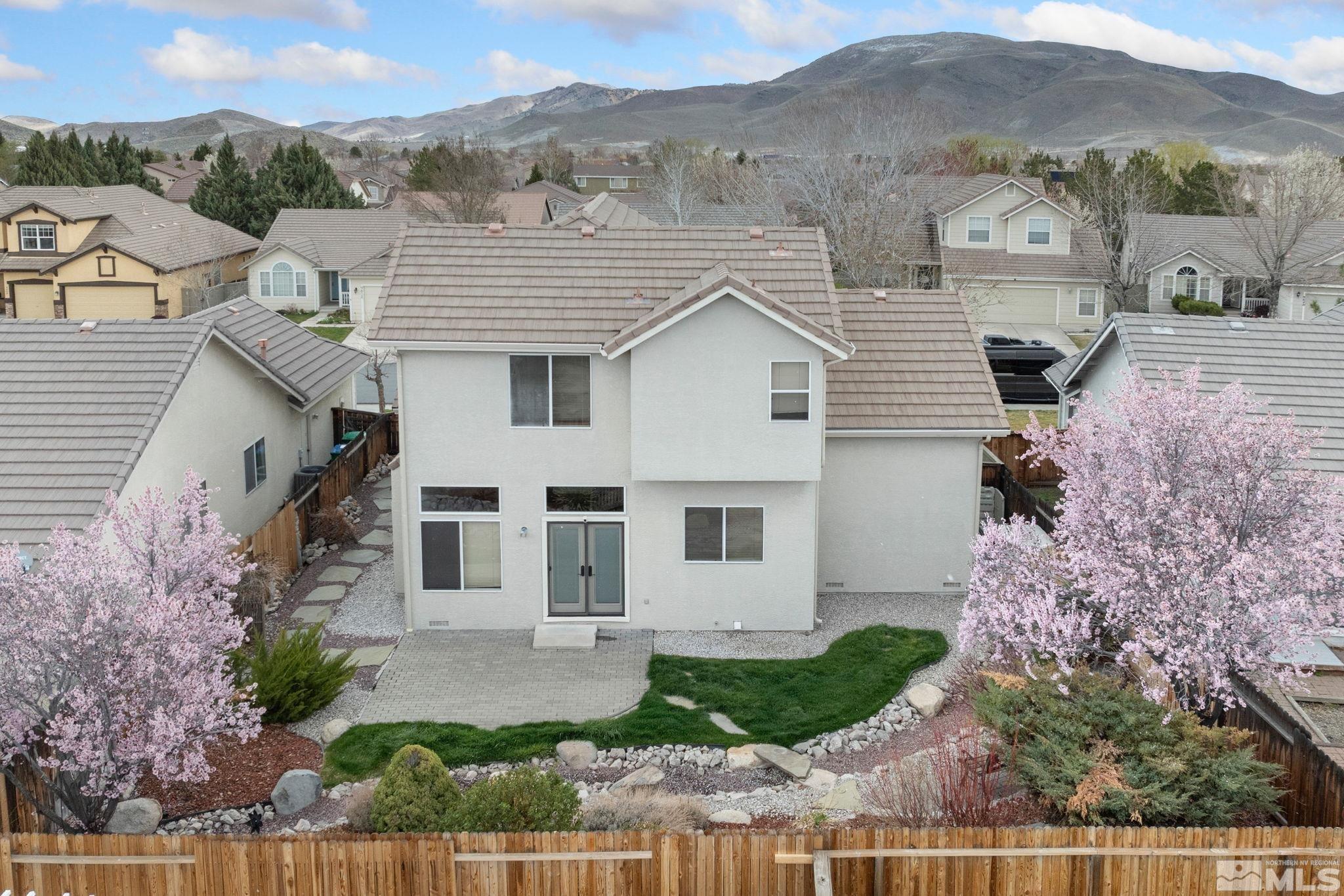 9635 Oakley Lane Reno, NV 89521 - Photo 39 of 40 a view of a white house next to a yard with plants and large trees
