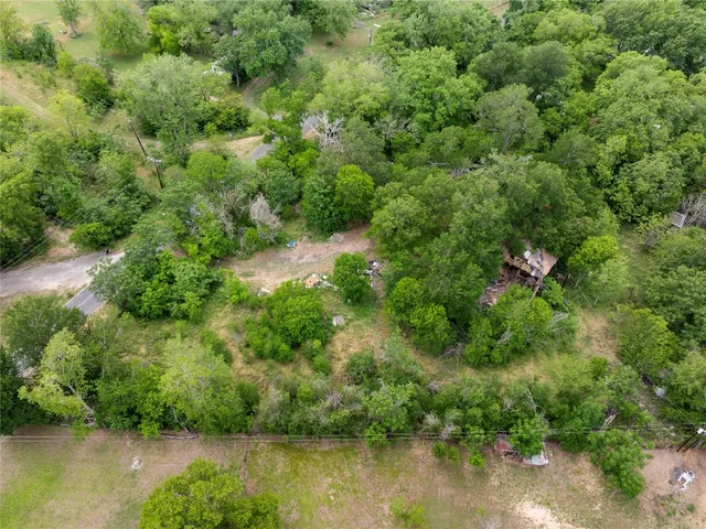 an aerial view of residential house with outdoor space and trees all around