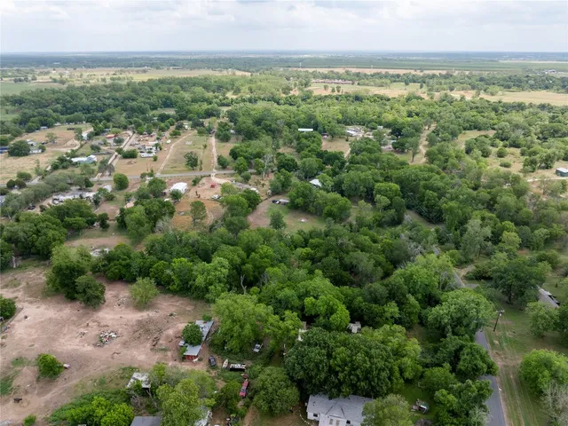 an aerial view of residential houses with outdoor space and trees