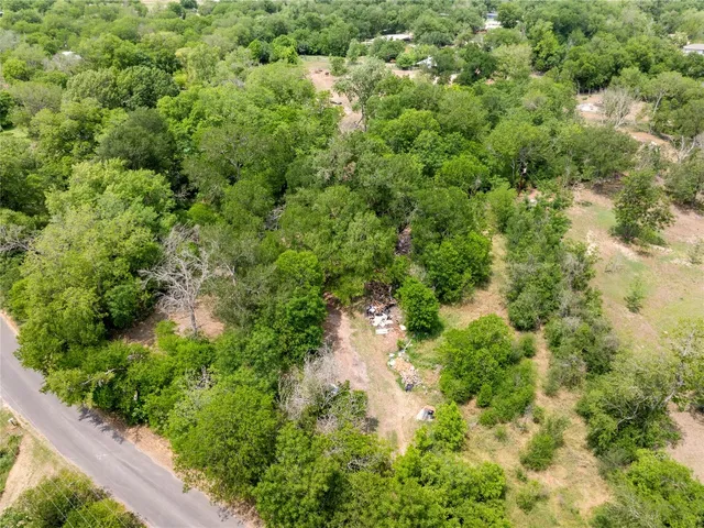 an aerial view of residential house with outdoor space and trees all around