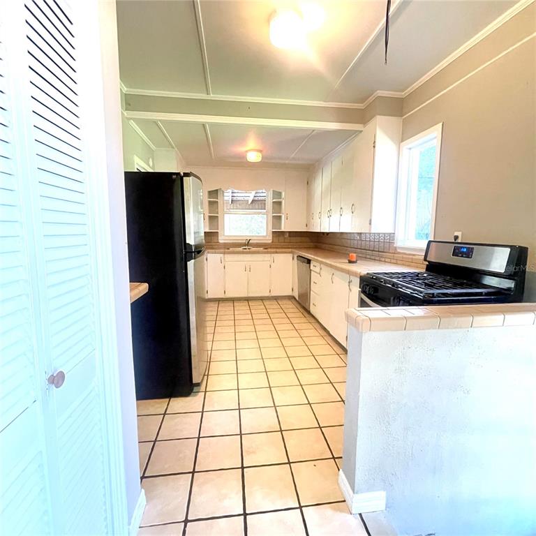 915 East Walnut Street Lakeland, FL 33801 - Photo 11 of 27 a kitchen with stainless steel appliances a refrigerator a sink a stove a microwave and cabinets