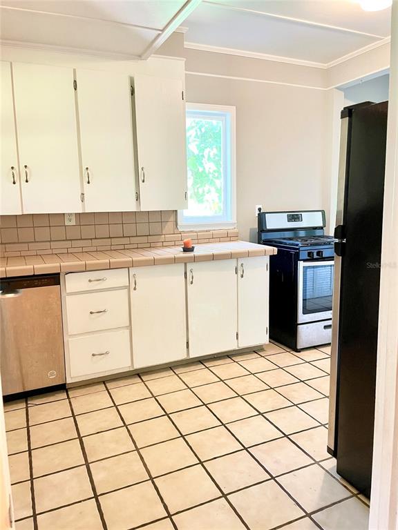 915 East Walnut Street Lakeland, FL 33801 - Photo 14 of 27 a kitchen with stainless steel appliances a stove sink and cabinets