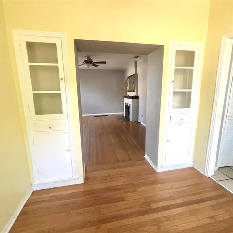 a view of a hallway with wooden floor and closet