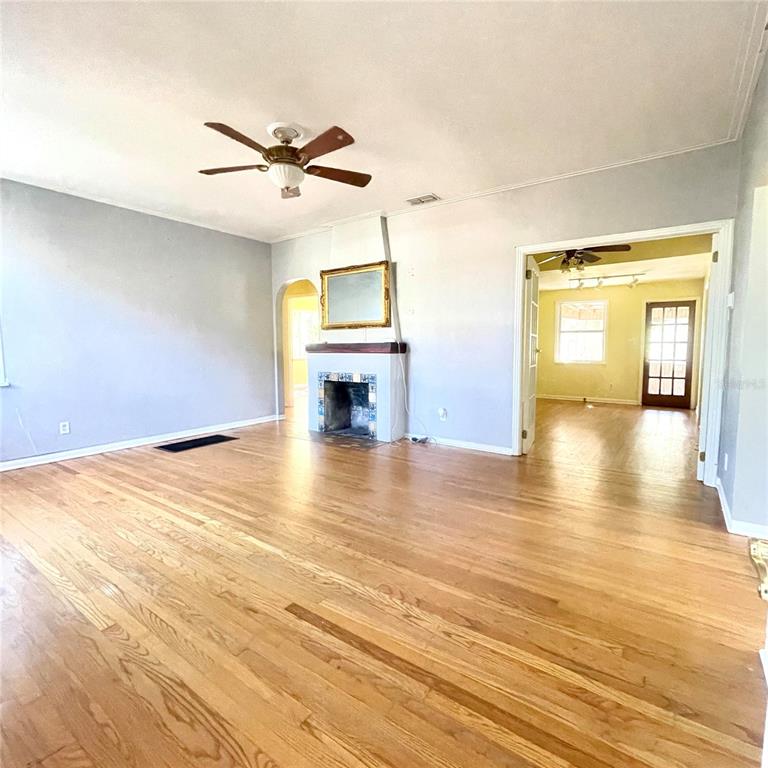 915 East Walnut Street Lakeland, FL 33801 - Photo 8 of 27 a view of a livingroom with a fireplace a ceiling fan and wooden floor