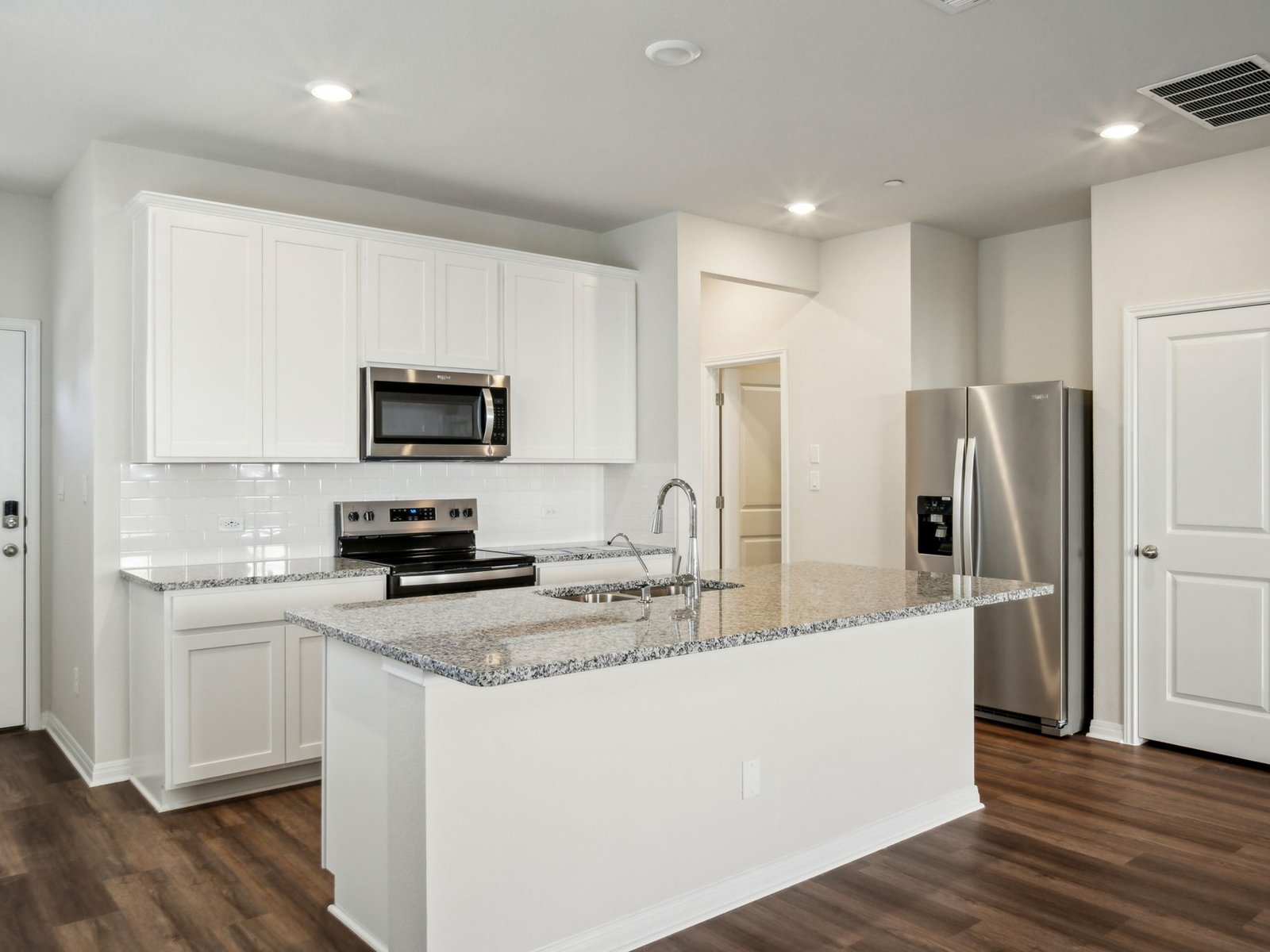 165 Calcite Road, Unit 3 Kyle, TX 78640 - Photo 6 of 17 a kitchen with refrigerator a microwave a sink and cabinets