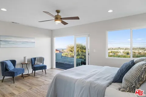 a spacious bedroom with a bed and wooden floor