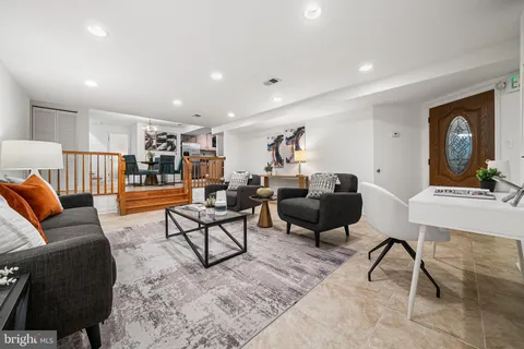 a dining room with stainless steel appliances kitchen island granite countertop a dining table chairs and a refrigerator