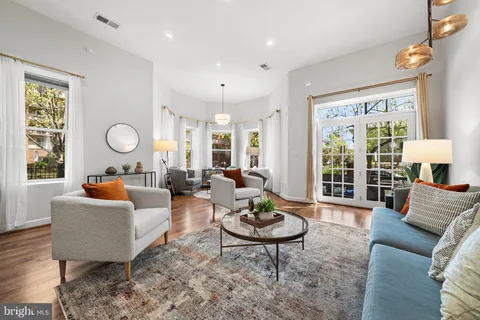 a living room with furniture a table and wooden floor
