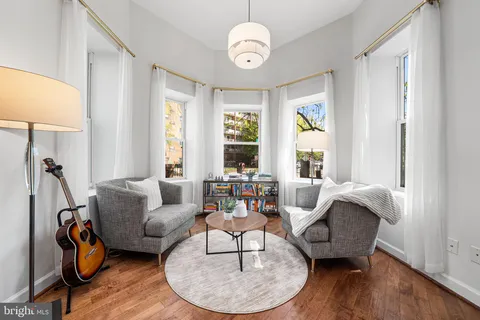 a living room with furniture a window and a clock
