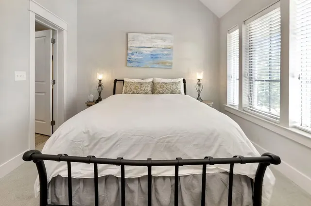 a large bed sitting in a bedroom next to a window