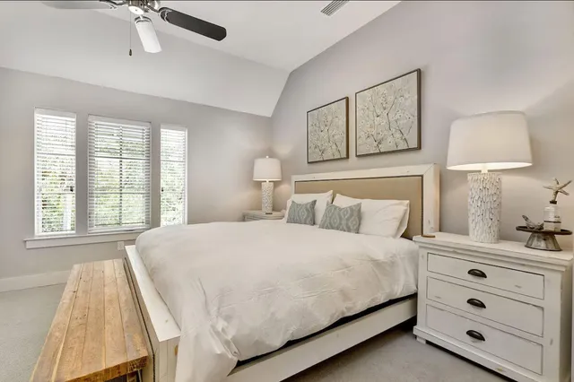 a bedroom with a bed and a lamp on dresser