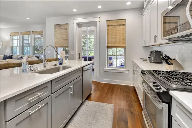 a kitchen with kitchen island a counter top space a sink a refrigerator and a stove