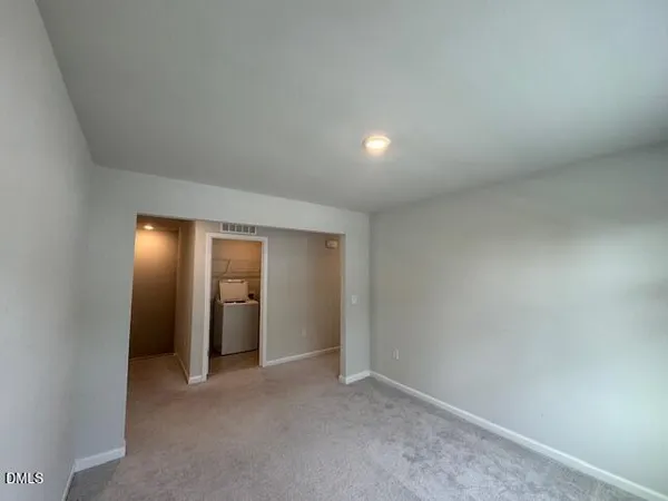 an empty room with closet and a mirror